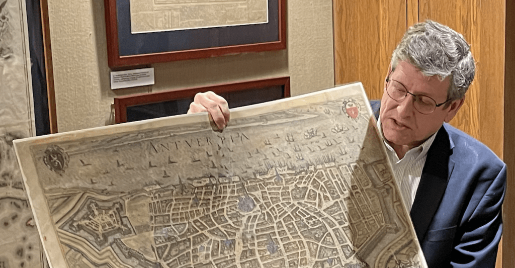 Photograph of Ben Huseman holding a large map.